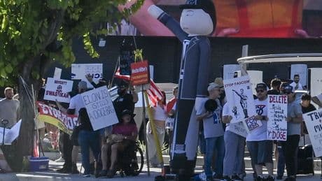 Tesla protesters take aim at Musk’s retro-style diner with Nazi-styled balloons — even as lines stretch around the block