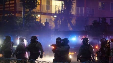 After tear gas and street fires, an Los Angeles community cleans up as National Guard troops arrive