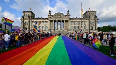 Berlin: CSD-Teilnehmende protestieren mit riesiger Regenbogenflagge vor Reichstag