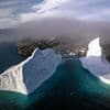Iceberg right ahead! Amazing images show skyscraper-sized frozen blocks drifting towards houses on Greenland's shores