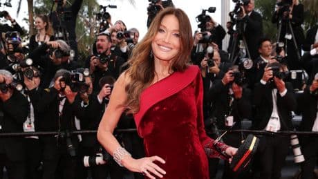 Dans une robe fendue en velours, Carla Bruni ose le rouge sur le tapis rouge