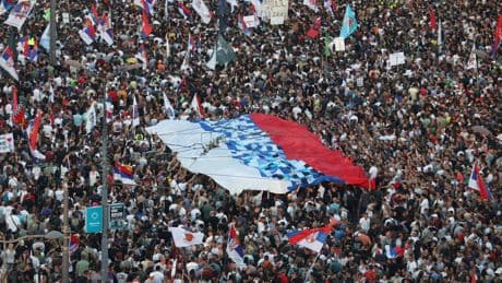 Tens of thousands rally in Serbia's capital to back up their demand for an early vote