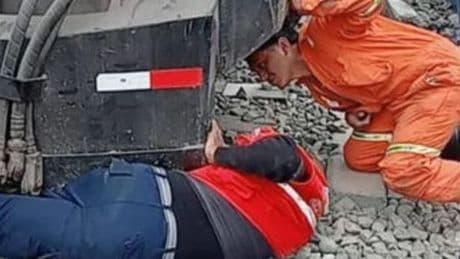 Inspector, 65, dragged beneath train after jumping on tracks to save teen girl