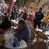 Moment cops form protective shield in front of holidaymakers dining at a Majorca restaurant as they are barracked by anti-tourist protesters
