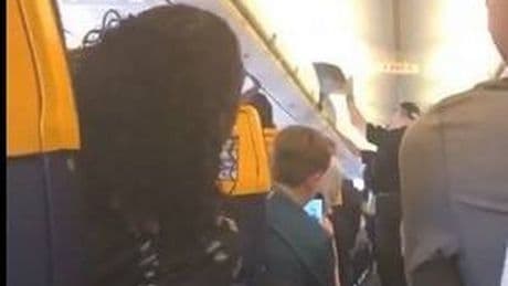 Moment police board Ryanair plane after woman 'tries to open emergency exit' mid-flight