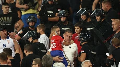 Riot police rush into stands as Serbia fans fight EACH OTHER in front of terrified children during England match