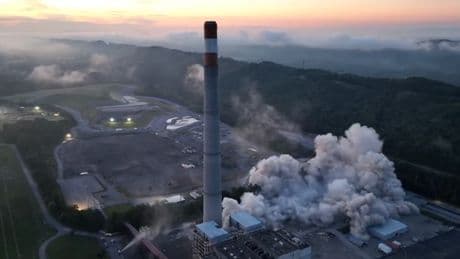 Moment 800-foot-tall power station chimney crumbles to ground in blast