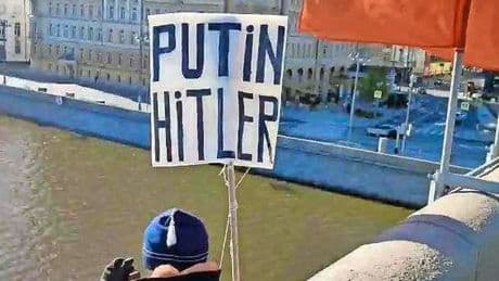 Man protesteert tegen Poetin tegenover het Kremlin, springt daarna van een brug