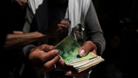 Cash is scarce in Gaza. Palestinians are paying a high price to get it