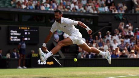 Zijn oude rivaal Roger Federer knikt Novak Djokovic bemoedigend toe vanaf de tribune, na een game van 19 minuten
