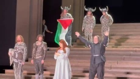 Un artista despliega una bandera palestina en el escenario de la Royal Opera House de Londres