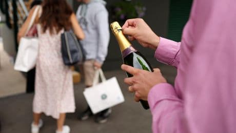Wimbledon fan pops champagne cork onto court and is scolded by umpire