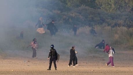 French police launch tear gas to clear migrants from beach