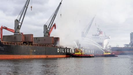 Was het een ontplofte batterij of metaalbroei? Op de kade naast het brandende vrachtschip kennen omstanders de oorzaak al