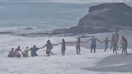 Beachgoers form human chain to save boy from being swept out to sea