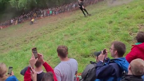 Moment daredevil dressed as wizard SOMERSAULTS down hill in pursuit of 7lb wheel of cheese in bonkers annual competition
