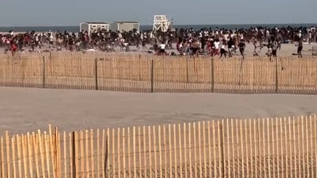 Watch moment police helicopter breaks up mass beach brawl between high school kids sending them scrambling