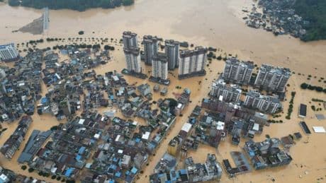 Driver left dangling over edge of a bridge after massive landslides in China
