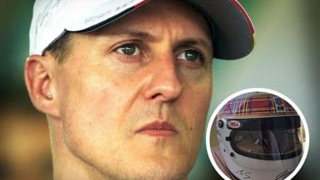 Michael Schumacher, con ayuda de su mujer, firma un casco para una causa benéfica