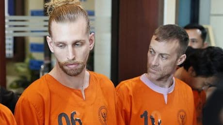 British pair accused of smuggling cocaine into Bali are paraded handcuffed together as they face possible death penalty