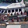 First small boat migrants are detained for removal to France under new 'one-in, one-out' scheme after arriving in Dover yesterday