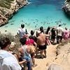 The 'secret' Spanish paradise beach ruined by influencers: Videos show piles of rubbish and tourists queuing to reach sand at Majorca beauty spot lauded by Instagrammers