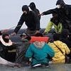 Chaos on French shores as 'people trafficker' is seen WHIPPING terrified migrants as they scramble to board boat bound for the UK