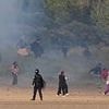 The battle of Calais: Gangs of migrants stream past French police and through tear gas to waiting 'taxi boats' yelling 'England, England!'
