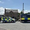 'Army' of police shut down crime boss 'Hotdog' Smith's house on illegal scrapyard as wife says she will be forced to live 'in a TENT'