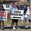 Anti-immigrant demonstrators stare down pro-migrant counter protesters outside asylum hotel