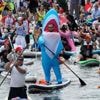 Photos show costumed participants steer stand-up paddle boards at a festival in Russia