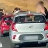 Tourists are filmed hanging dangerously out of moving cars on Spanish holiday island - before they are caught and fined