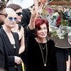Ozzy Osbourne's family gather to lay him to rest in the grounds of his mansion in front of huge tongue-in-cheek sign with stars including Elton John among mourners