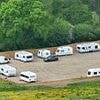 Travellers in fleet of caravans take over huge field in the South Downs National Park after the land was illegally torn up by diggers over Bank Holiday weekend