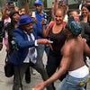 Crazed Diddy fans are removed by riot police after spraying each other in baby oil outside court