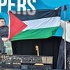 Irish band are hauled off stage at UK festival after starting pro-Palestine chant and brandishing flag - but are backed by rappers Kneecap