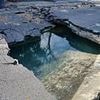Massive sinkhole opens up in busy UK street after burst pipe causes major flooding