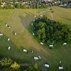 Travellers pitch up illegal encampment with up to 30 caravans on huge field next to Surrey's million pound homes
