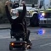 Elderly man challenges riot police on his mobility scooter while wearing a Roman helmet in Ballymena