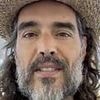 Russell Brand says he 'welcomes' rape trial 'because I know I'm innocent' as he touches down in UK for first hearing after first class flight from US