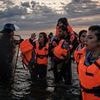 French police TEAR GAS migrants and enter the water to drag them back to shore but are overwhelmed by sheer numbers as more boats head for Britain