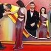 Rachel Brosnahan stuns in a glittering cut-out red dress as her co-star David Corenswet sweetly kisses her hand at Superman fan event in London