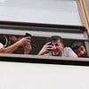 Migrant hotel residents film and laugh as they watch protesters and counter-demonstrators clash on streets of Islington