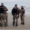 Moment migrant 'taxi boat' stops to collect crowd of waist-deep UK-bound asylum seekers off Calais - with French cops watching on and banned from intervening